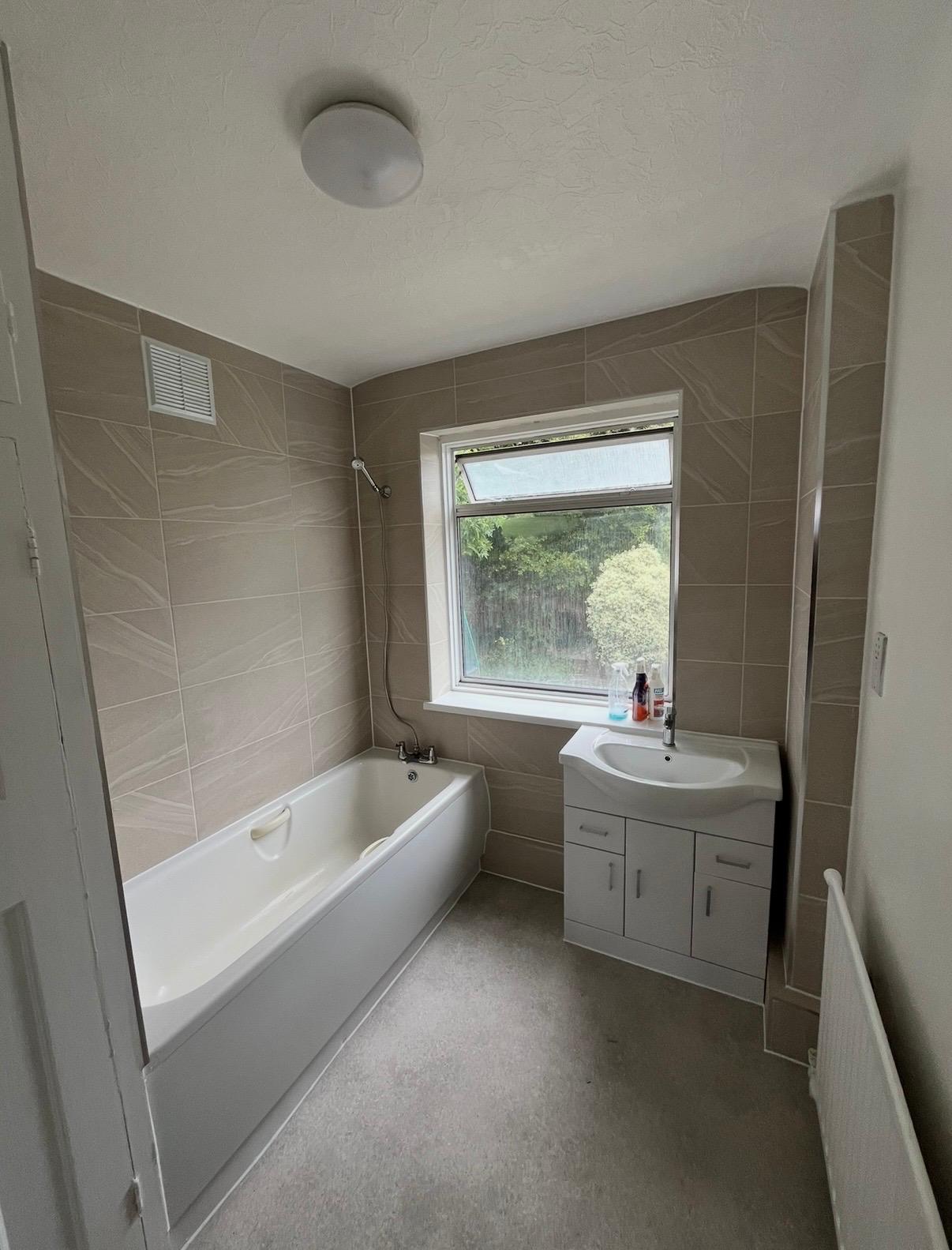Modern bathroom suite with bath, vanity unit and window, London & Essex